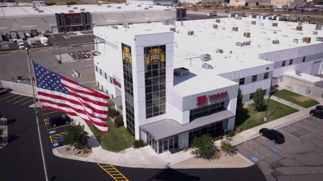Aerial view of large commercial building with US flag outside.